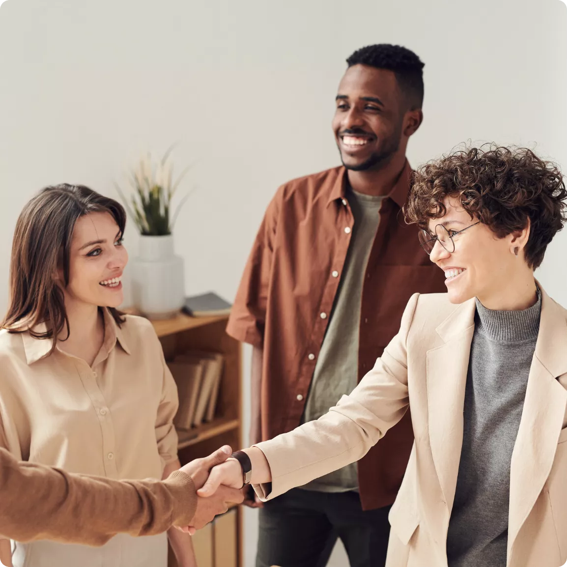 hommes et femmes souriants se serrant la main