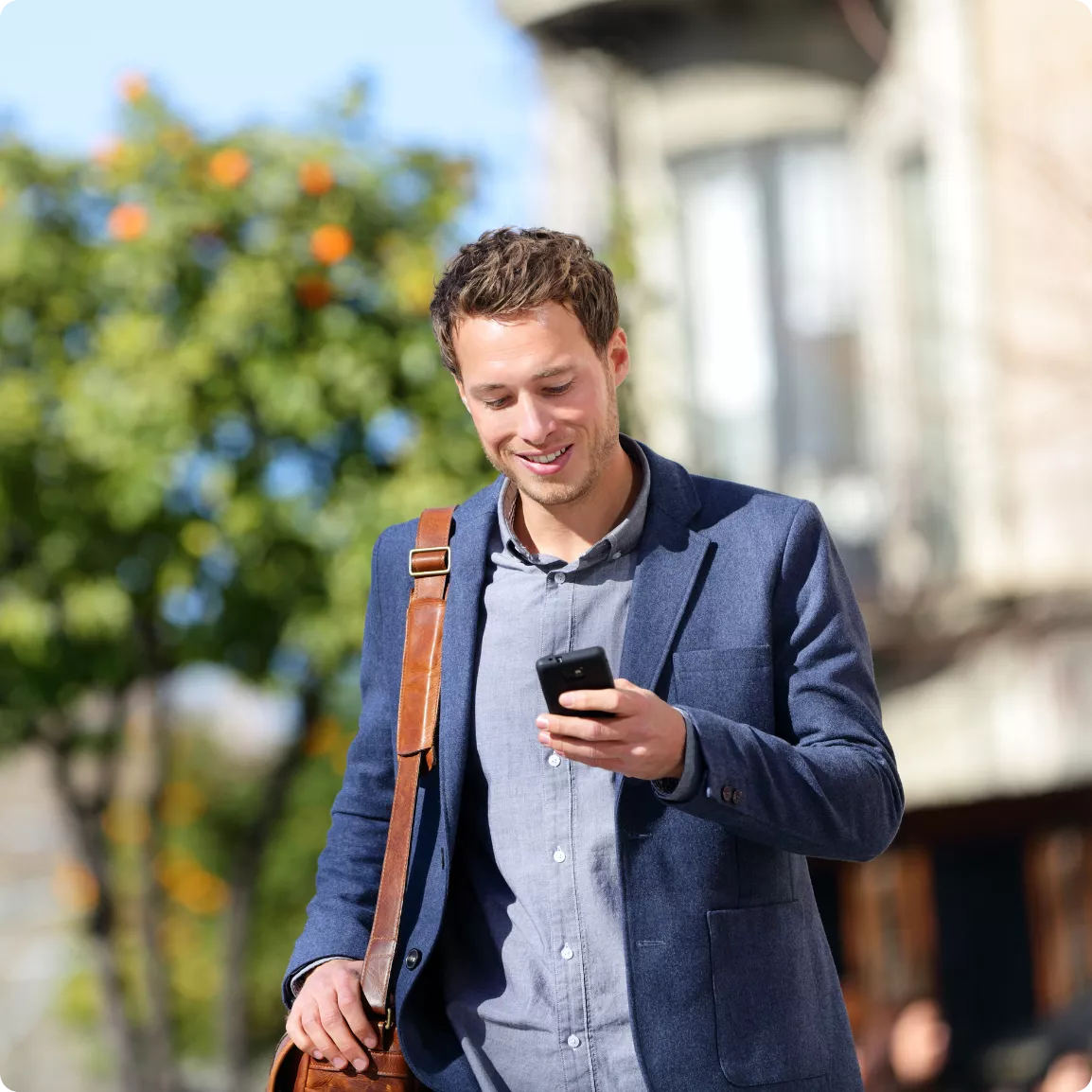 Homme marchant dans la rue un téléphone à la main