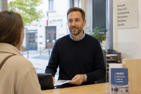 Agent d’accueil en mairie échangeant avec une administrée pour optimiser la gestion des rendez-vous et améliorer la qualité du service citoyen
